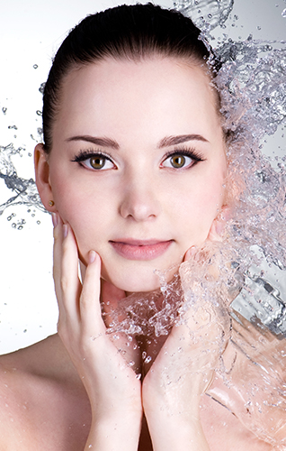Blast of water falling on the face of a beautiful and young woman