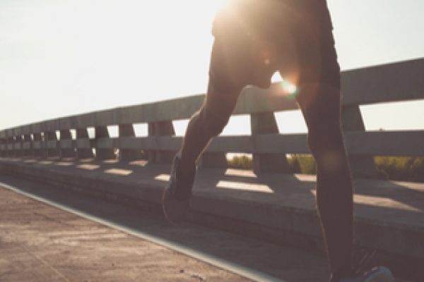 Man running outdoors next to a fence